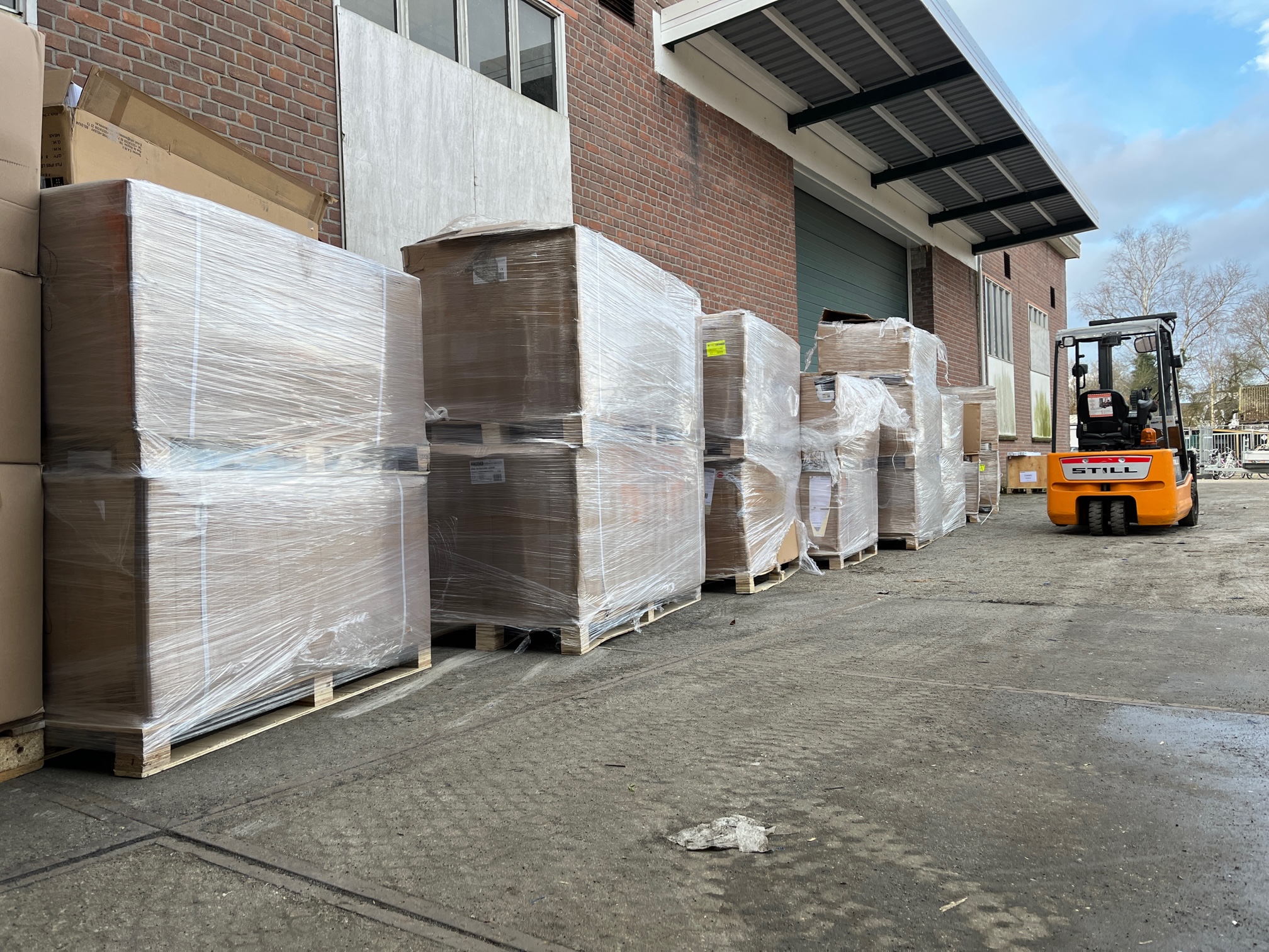 Pallets met retourgoederen en magazijnvoorraad klaar voor veiling, buiten bij magazijn, opgehaald door opkoper Veilinghuis Nederland.
