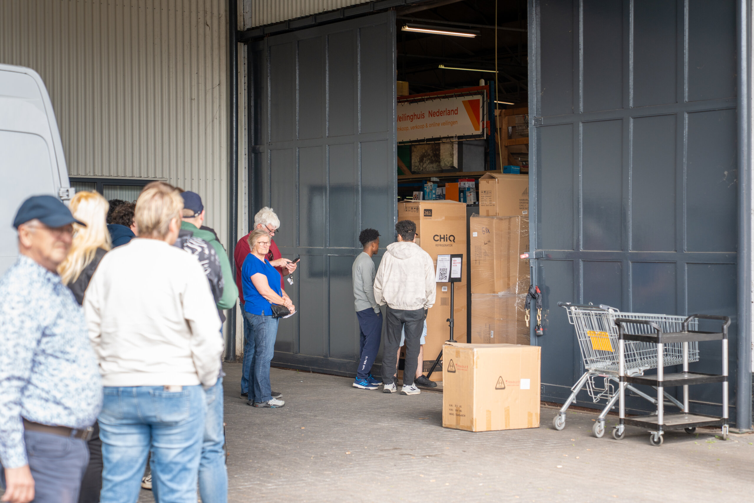 Particulieren en bedrijven halen gewonnen kavels op tijdens veiling afgifte
