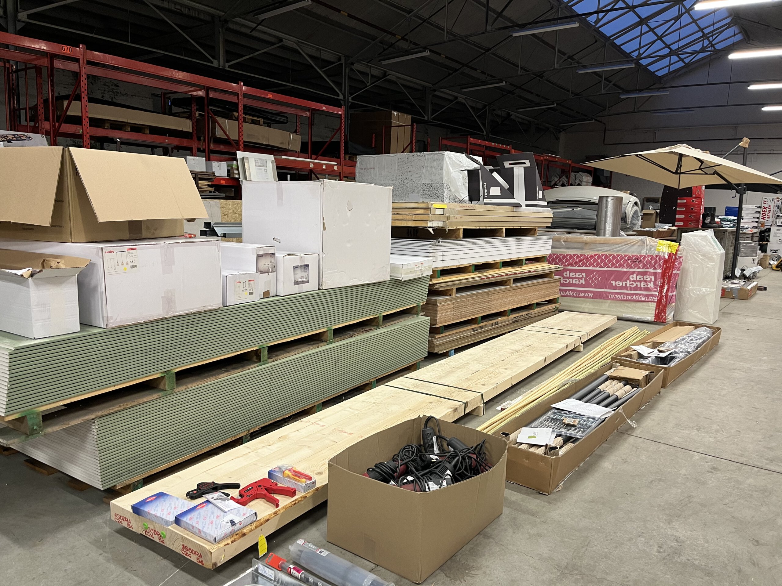 Opkoper bouwmaterialen met pallets hout, isolatie en restpartijen in professioneel magazijn