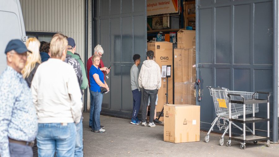 Kopers halen aangekochte goederen op tijdens afgifte dag