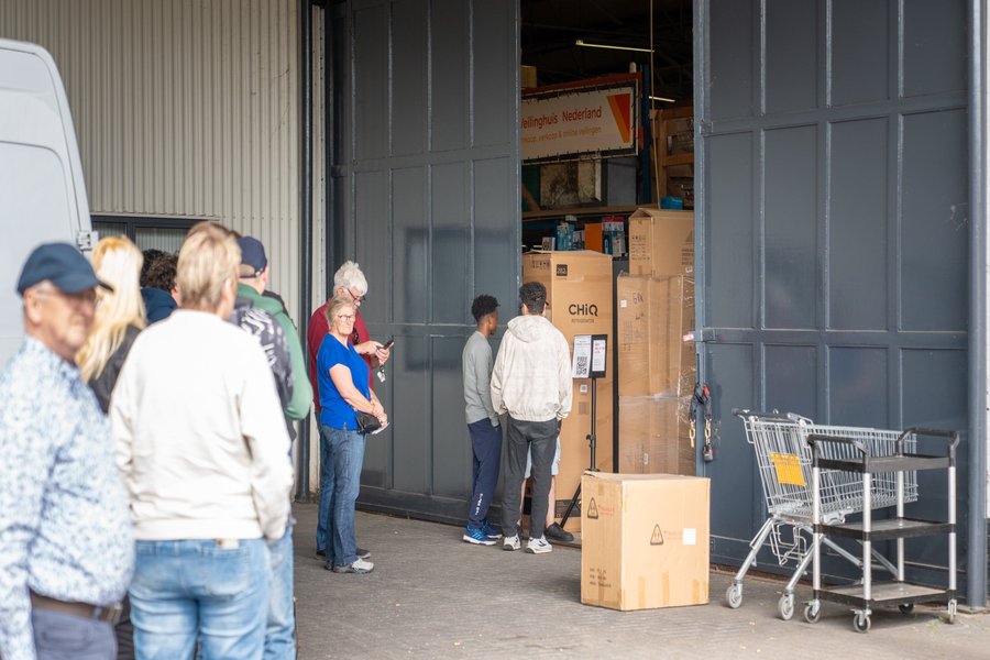 Kopers halen aangekochte goederen op tijdens afgifte dag