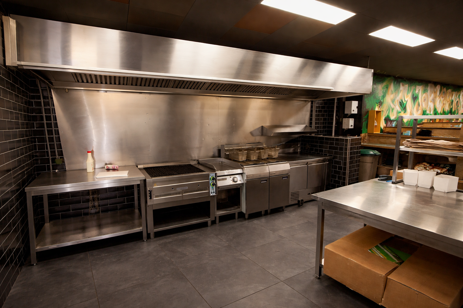 Professionele RVS horeca keuken met bakwand, afzuigkap en commerciële keukenapparatuur geschikt voor opkoop en verkoop via online veiling.