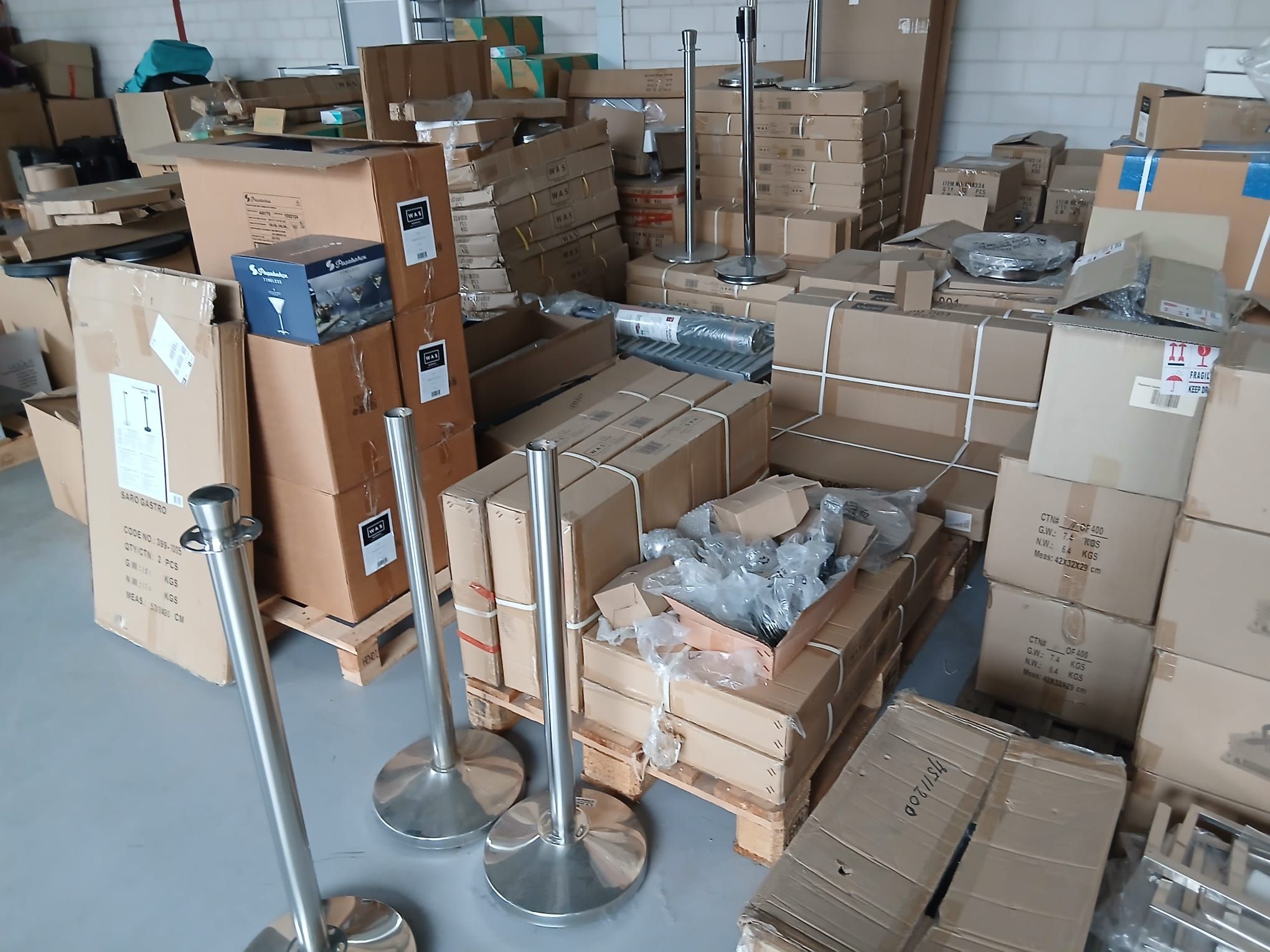 Magazijnstelling gevuld met diverse horeca artikelen en voorraad in dozen