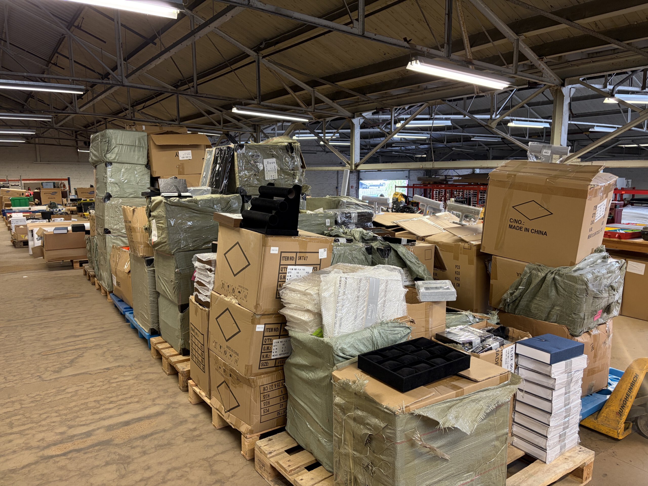 Retourgoederen en overtollige webshopvoorraad die worden voorbereid voor een online e-commerce veiling.