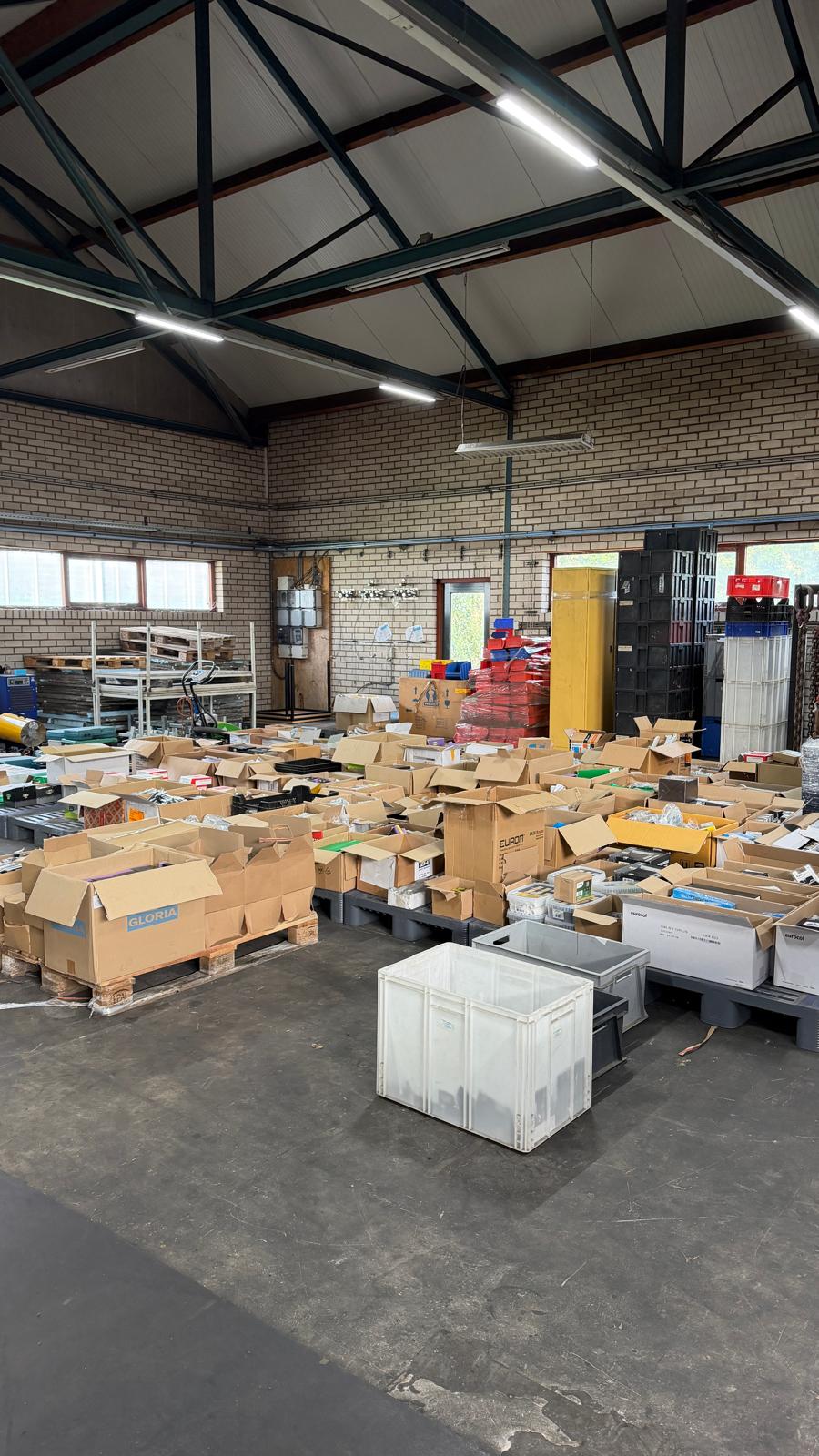 Overzicht van bouwmaterialen en technische producten op pallets in een magazijn