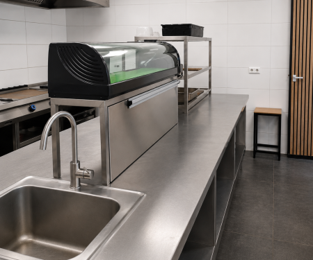 Moderne professionele horeca keuken met RVS werkbanken, spoelbak en horecaopstelling voor verkoop of opkoop.